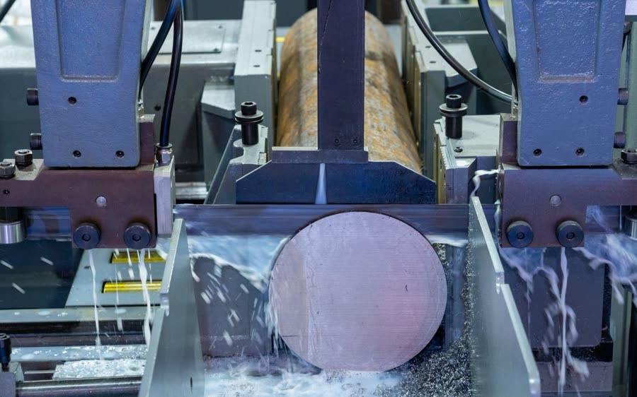 Bandsaw cutting a round steel bar under coolant