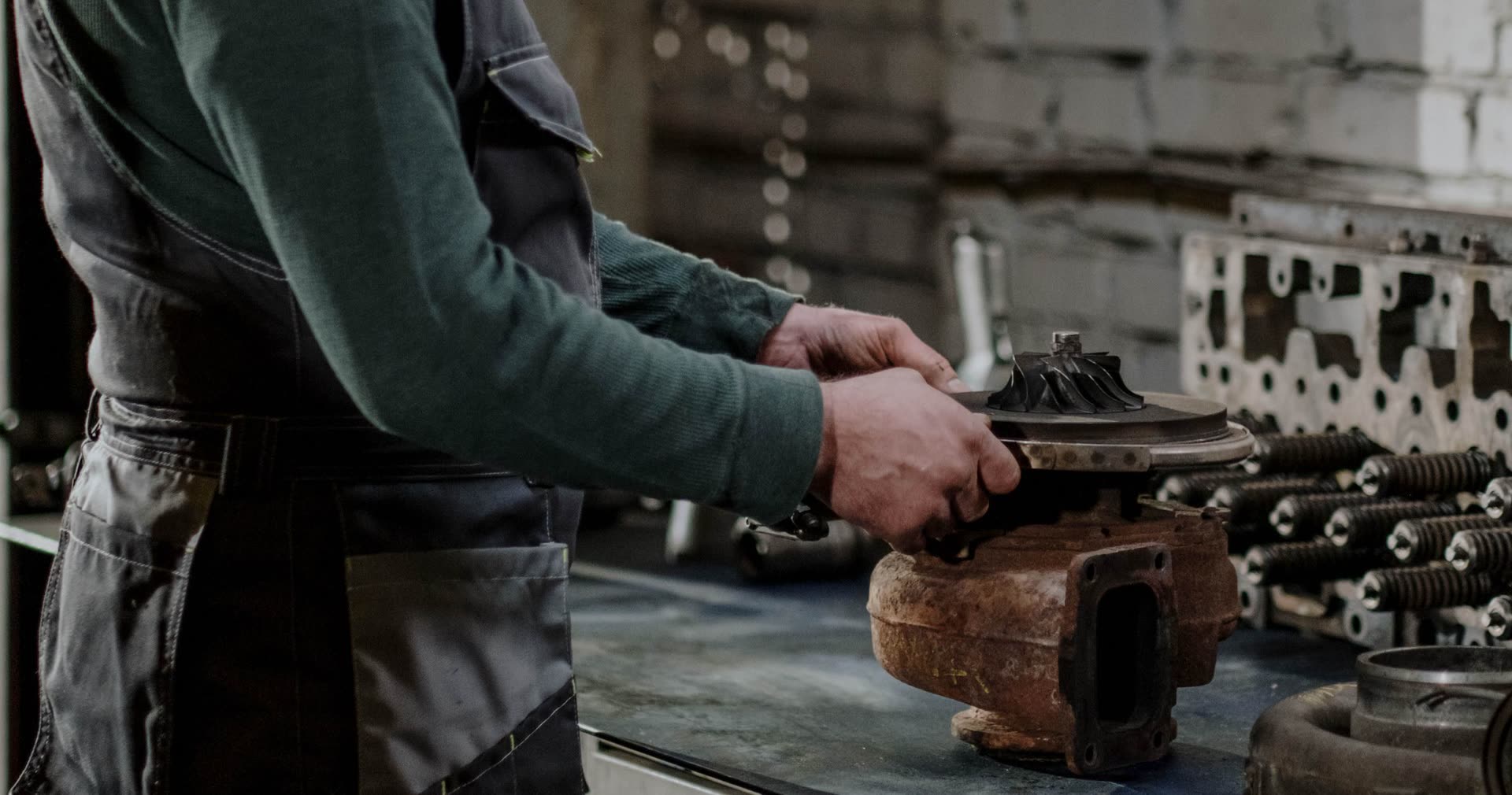 Hands fitting a new core into a worn turbocharger housing on a shop bench